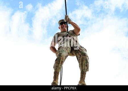 Sgt. 1st Class Jose Gonzalez, first sergeant for the 7251st Medical Support Unit, Albuquerque, N.M., negotiates the rappel tower at the Air Assault Obstacle Course during the third annual Community Outreach Day at Fort Bliss Aug. 25. This year’s event was coordinated by the 210th RSG and the 1st Armored Division Iron Training Detachment - along with volunteers of Child Crisis Center, Big Brothers Big Sisters, and the El Paso Police Department – to mentor and interact with citizens of El Paso, Texas. Stock Photo