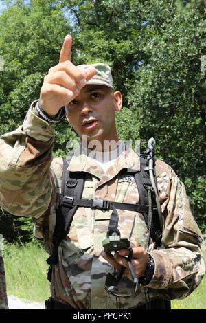 U.S. Army Spc.Michael A. Lopez of Guanica, Puerto Rico, a mortuary affairs specialist for the 246th Quartermaster Company, points the way for his team during a land navigation test at Fort Pickett, Va., Aug. 12, 2018. More than 300 Army Reserve Soldiers from across the United States attended the Mortuary Affairs Exercise, which also included marksmanship, search and recovery operations and other training. Stock Photo