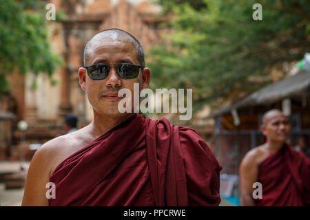 Head and shoulders portrait of Buddhist monk wearing sunglasses, Bagan, Mandalay, Myanmar Stock Photo