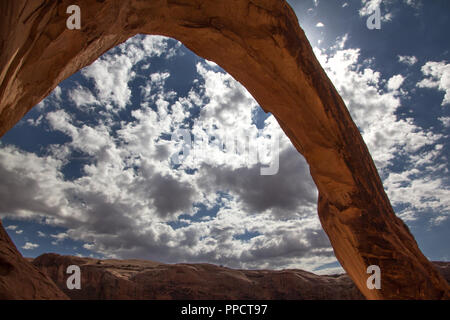Corona Arch silhouetted against the sun. A free standing sandstone arch near Moab Utah. Stock Photo