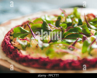 beetroot pizza crust with fresh swiss chard or mangold, beetroot leaves. Ideas and recipes for vegan snack.Egg-free pizza crust with chia seeds and wholegrain brown rice flour. Copy space. Shallow DOF Stock Photo