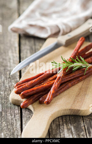 Sausage sticks snack. Chorizo snack on cutting board. Stock Photo