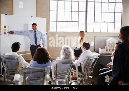 Businessmastands using whiteboard during a presentation Stock Photo
