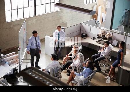 Businessman giving presentation to colleagues, elevated view Stock Photo