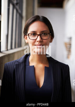 Young mixed race businesswoman wearing glasses, vertical Stock Photo