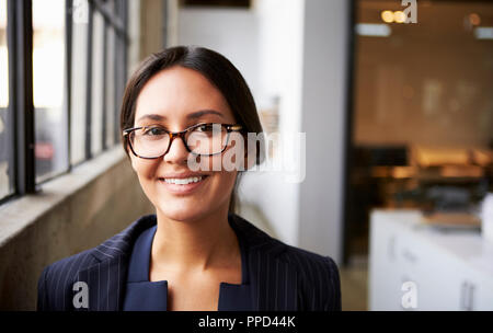 Young mixed race businesswoman wearing glasses, close up Stock Photo