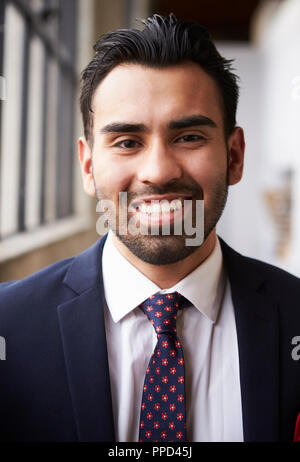 Young Hispanic businessman smiling to camera, vertical Stock Photo