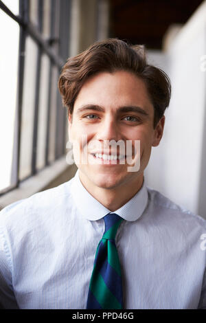Young white businessman smiling, vertical portrait Stock Photo