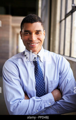 Smiling mixed race businessman with arms crossed, portrait Stock Photo