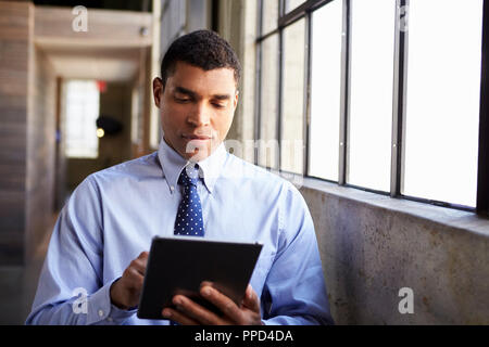 Mixed race businessman using tablet computer Stock Photo