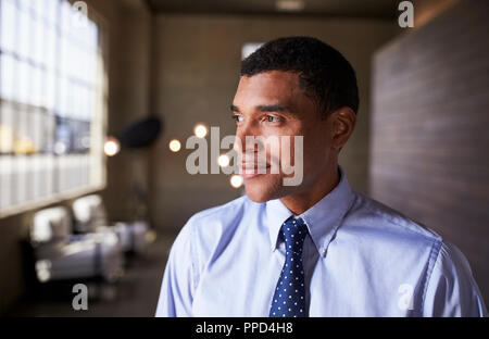 Mixed race businessman looking away smiling, close up Stock Photo
