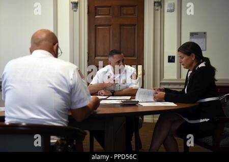 Scott Little, center, fire chief of Lancaster’s Bureau of Fire, and David Amico, deputy chief of Lancaster’s Bureau of Fire, meet with Lancaster’s Mayor Danene Sorace to discuss the possible addition and remodeling of firehouses as well as improving their fire rescue service delivery Aug. 21, 2018, Lancaster, Pennsylvania. The meeting resulted in Sorace approving a budget of up to 10 million dollars for this specific project. Stock Photo