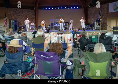JOHNS CREEK, Ga. (Aug. 31, 2018) Audience members enjoy a performance by the U.S. Navy Band Country Current at the Mark Burkhalter Amphitheater at Newtown Park in Johns Creek, Georgia. Country Current is on a ten-day tour through Virginia, North Carolina, Georgia and Florida, entertaining audiences while connecting Americans to their Navy. Stock Photo