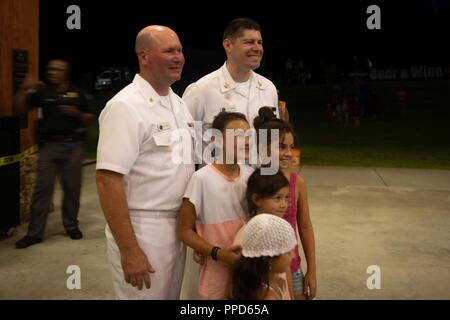 JOHNS CREEK, Ga. (Aug. 31, 2018) Senior Chief Musician Pat White, left, and Musician 1st Class Joe Friedman of the U.S. Navy Band Country Current pose for a photo with young fans after a performance  at the Mark Burkhalter Amphitheater at Newtown Park in Johns Creek, Georgia. Country Current is on a ten-day tour through Virginia, North Carolina, Georgia and Florida, entertaining audiences while connecting Americans to their Navy. Stock Photo