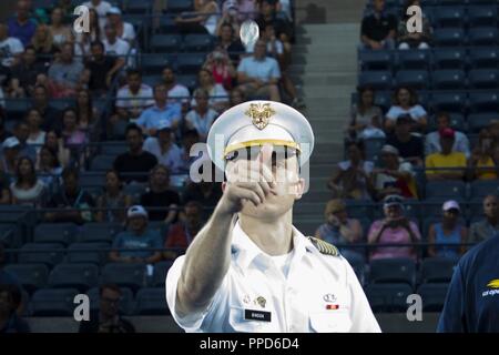 U.S. Military Academy at West Point’s First Captain Cadet David Bindon tosses a coin to determine with serves first during the U.S. Open’s 7th Annual Military Appreciation Day Aug. 3, 2018.    During the event, Lt. Gen. Darryl A. Williams, USMA Superintendent, presented a flag to Johnnie Ashe, brother of Arthur Ashe, tennis legend and former West Point tennis coach. In 1968, Johnnie volunteered for a second tour of duty in Vietnam so Arthur could stay at West Point and continue his storied tennis career. Stock Photo