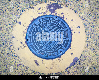 A manhole cover showing the Yokohama Bay Bridge.  Yokohama, Japan. Stock Photo