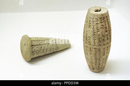 Near East. Mesopotamia. Clay cone with an inscription of Gudea. Lagash. 22nd Century BC. Clay cylinder with an inscription of Nebuchadnezzar II. Babylonia. 6th BC. The State Hermitage Museum. Saint Petersburg. Russia. Stock Photo