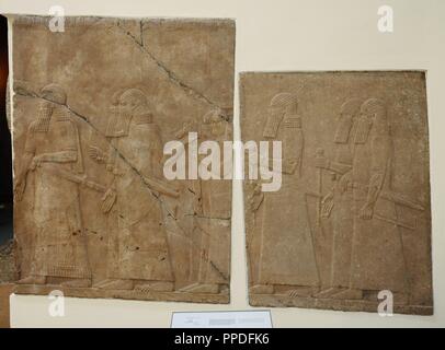 Mesopotamian art. Assyrian. Orthostates with reliefs in the side walls of a ramp from the Palace of Nineveh. Alabaster. 704-689 B.C. It shows Assyrian officers and courtiers carrying a mobile throne. Pergamon Museum. Berlin. Germany. Stock Photo