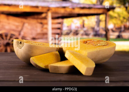 Group of two halves three slices of smooth pear shaped orange butternut squash waltham variety with cart in background Stock Photo