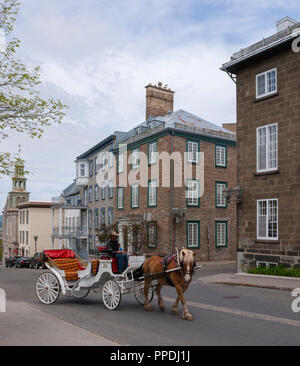 Carriage ready to pick up tourists for a tour. City quarter in Old Quebec with stone townhouses lining a street corner on Rue D'Auteuil, Quebec City. Stock Photo