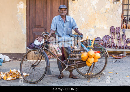 Galle, Sri Lanka - August, 8, 2017: Poor old man selling coconuts in the old town of Galle in Sri Lanka Stock Photo