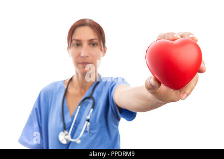 Woman cardiologist or nurse in cardiology clinic holding focused red heart shape as professional medical assistance isolated on white studio backgroun Stock Photo