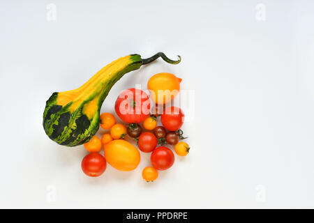 Pumpkin and red, yellow tomatoes on a white background. Stock Photo