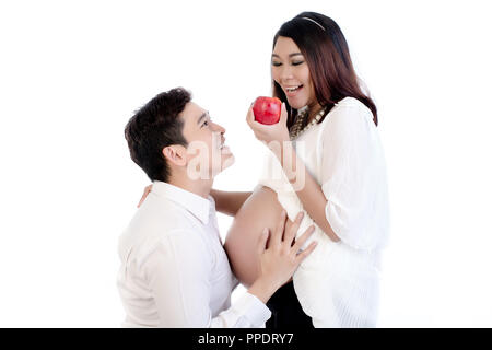 Man looking at his pregnant wife holding apple Stock Photo