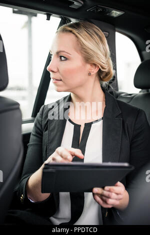 Businessman holding digital tablet in car Stock Photo