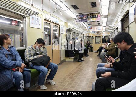 OSAKA, JAPAN - NOVEMBER 22, 2016: Passengers ride a Hankyu train in Osaka. Hankyu Corporation exists since year 1910. Stock Photo