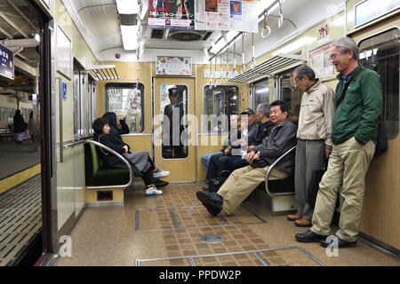 OSAKA, JAPAN - NOVEMBER 22, 2016: Passengers ride a Hankyu train in Osaka. Hankyu Corporation exists since year 1910. Stock Photo