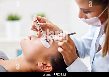 Adult woman having eyelash extension in professional beauty salon Stock Photo