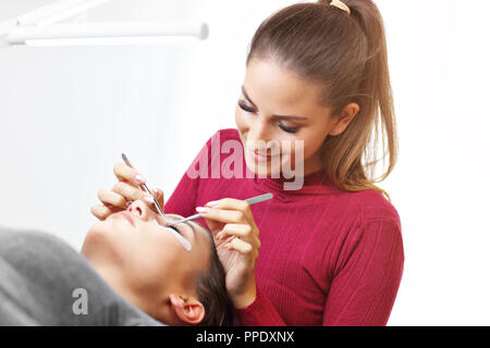 Adult woman having eyelash extension in professional beauty salon Stock Photo