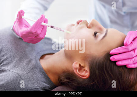 Attractive young woman gets cosmetic face injection Stock Photo