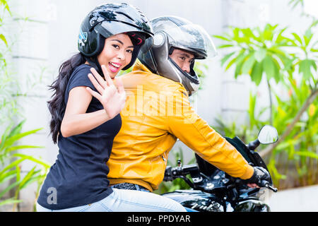 Girlfriend riding with boyfriend on motorbike Stock Photo
