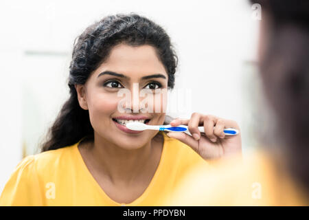 Smiling woman brushing teeth Stock Photo