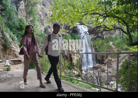 Young couple taking a walk near a waterfall ( Kyrgyzstan) Stock Photo