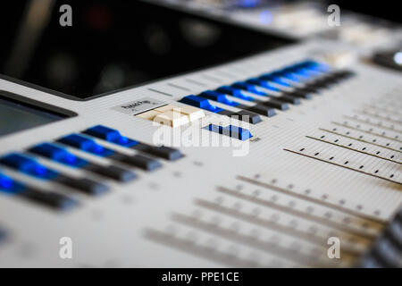 Digital Display and control Faders on Professional Lighting Designers Programming desk, controller Console, white desk and grey Faders Stock Photo
