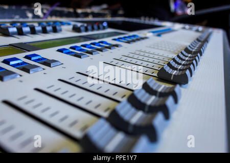 Digital Display and control Faders on Professional Lighting Designers Programming desk, controller Console, white desk and black Faders Stock Photo