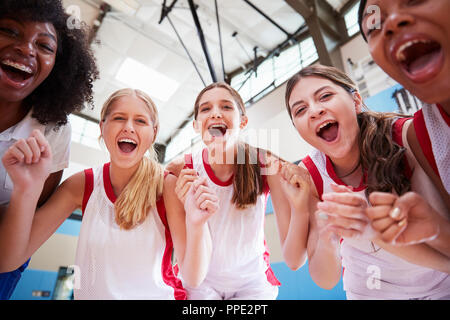 Portrait Of Female High School Basketball Team Celebrating With Coach Stock Photo