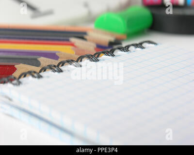 close-up of blurred image of checkered Notepad and pencils on white background Stock Photo