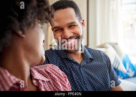 Couple Chatting And Relaxing On Sofa At Home Together Stock Photo