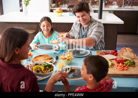 Family Enjoying Meal Around Table At Home Together Stock Photo