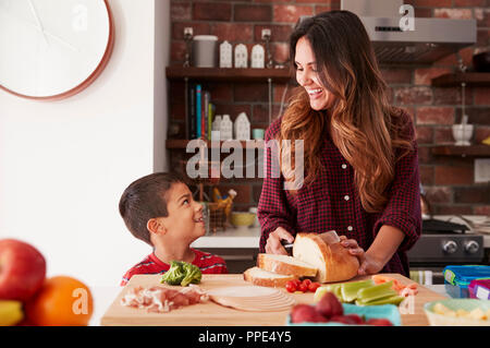 Mother And Son Making School Lunch In Kitchen At Home Stock Photo