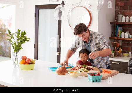 Father And Son Making School Lunch In Kitchen At Home Stock Photo