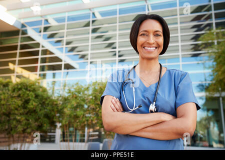 Smiling mixed race female healthcare worker outside hospital Stock Photo
