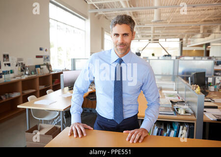 White male architect behind desk in office looking to camera Stock Photo