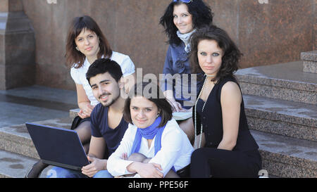 group of students communicating via the Internet using laptop Stock Photo