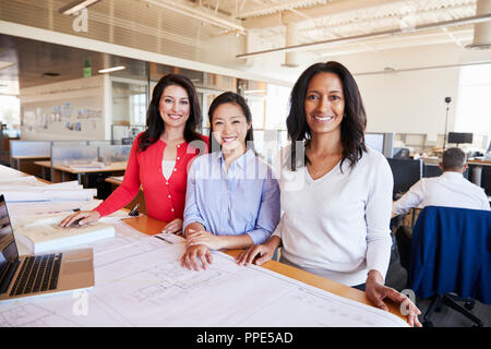 Three female architects working together look to camera Stock Photo