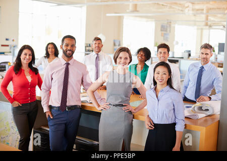 Business colleagues smiling to camera in an open plan office Stock Photo